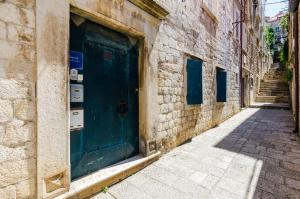 an alley with a green door on a stone building at Old Town Baroque Palace Accommodation in Dubrovnik