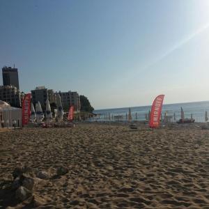 a beach with chairs and umbrellas and the ocean at Beach House Cabacum in Golden Sands