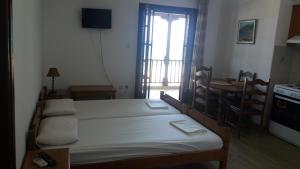 a bedroom with a bed and a kitchen with a table at House Kosmas on the beach in Sarti