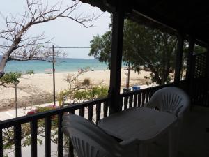 a porch with two chairs and a view of the beach at House Kosmas on the beach in Sarti