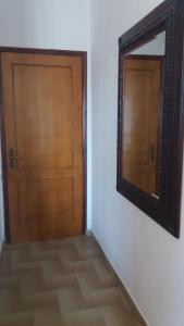 a wooden door and a mirror on a wall at House Kosmas on the beach in Sarti