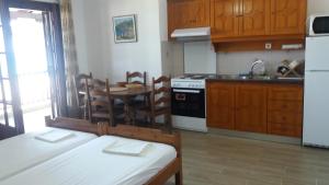 a kitchen with wooden cabinets and a table and a sink at House Kosmas on the beach in Sarti