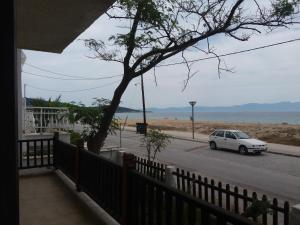 a white car parked on a street next to the beach at House Kosmas on the beach in Sarti