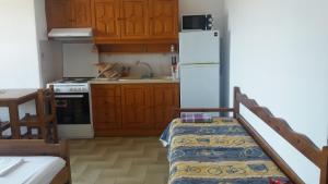 a kitchen with wooden cabinets and a white refrigerator at House Kosmas on the beach in Sarti
