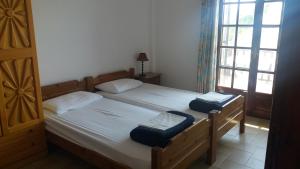 a bedroom with two twin beds and a window at House Kosmas on the beach in Sarti