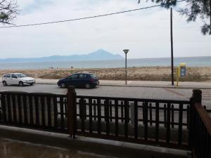 two cars parked on a street next to the beach at House Kosmas on the beach in Sarti