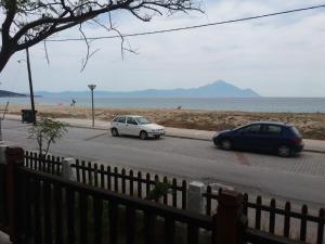 two cars parked on a street next to the beach at House Kosmas on the beach in Sarti