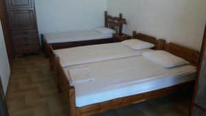 two beds in a room with white sheets at House Kosmas on the beach in Sarti
