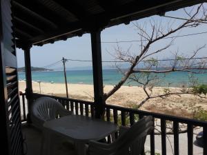 a table and chairs on a balcony with a beach at House Kosmas on the beach in Sarti
