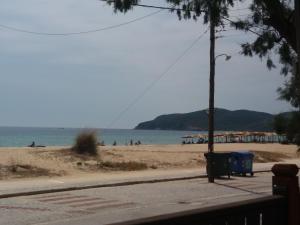 a beach with people on the sand and the water at House Kosmas on the beach in Sarti