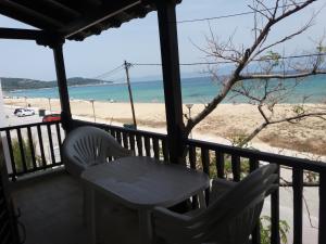 a table and chairs on a balcony overlooking the beach at House Kosmas on the beach in Sarti