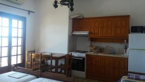 a kitchen with wooden cabinets and a table and a stove at House Kosmas on the beach in Sarti