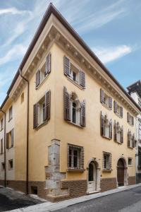 ein gelbes Gebäude mit Fensterläden auf einer Straße in der Unterkunft Residenza Palazzo Brenzoni in Verona