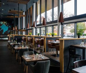 a restaurant with wooden tables and chairs and windows at Lifestyle-Appartement Meersinn in Waren