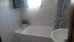 a bathroom with a bath tub and a sink at Rubama in Puerto del Carmen
