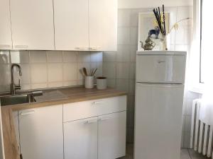 uma cozinha com armários brancos e um frigorífico branco em La Casina di Zaira em Rimini