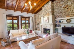 a living room with couches and a fireplace at Sunny Countryside Villa - With private pool in Faliraki