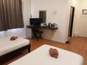 a room with two beds and a desk with a computer at Laos Haven Hotel in Vang Vieng