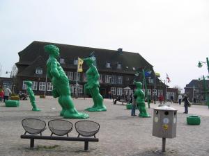 un groupe de statues vertes devant un bâtiment dans l'établissement Einzimmerappartement-fuer-zwei-Personen, à Westerland