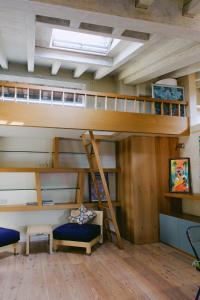 Litera en habitación con escalera y sofá en Attico dell'Artista, en Desenzano del Garda