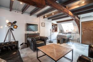a living room with leather furniture and a table at La Maison de Maurice in Beaune +31 photos