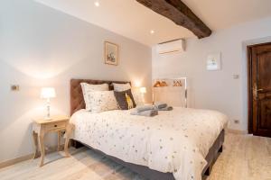 a bedroom with a large bed and a wooden floor at La Maison de Maurice in Beaune
