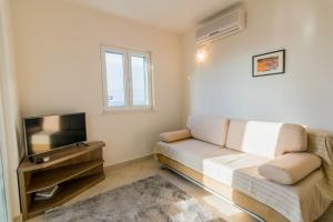 a living room with a couch and a flat screen tv at Apartman Emil in Supetar