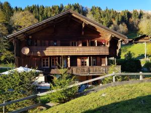 a large wooden house on a hill with a fence at B&B Chalet la Croisée in Vers L'Eglise