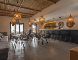 un ristorante con tavoli e sedie e un bar di My Mykonos Hotel a Mykonos Città