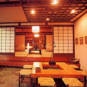 une chambre avec des tables et des chaises dans un bâtiment dans l'établissement Hakuba Alpine Hotel, à Hakuba