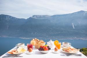 a table with a breakfast of fruit and eggs and juice at Hotel Le Balze - Aktiv & Wellness in Tremosine Sul Garda