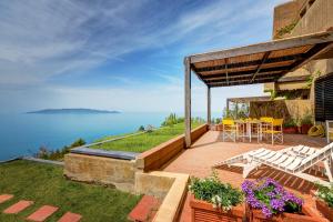 a patio with a table and chairs and the ocean at Terrazza Marina in Porto Santo Stefano