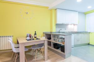 una cocina con mesa y sillas y un reloj en la pared en Zurriola - Beachside Comfort, en San Sebastián