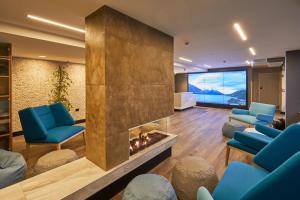 a living room with a fireplace and blue chairs at mi-pad Queenstown in Queenstown