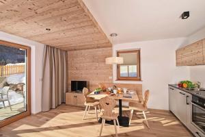 セストにあるSchäfer Apartmentsのテーブルと椅子のあるキッチンとダイニングルーム
