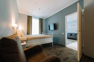 1 dormitorio con cama, sofá y espejo en Apartments Statskij Sovetnik, en San Petersburgo