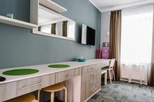 a bathroom with a counter with chairs and a sink at Apartments Statskij Sovetnik in Saint Petersburg