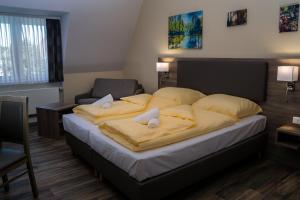 a bedroom with a large bed with yellow pillows at Hotel Dea in Soltau