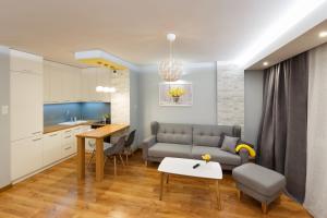 - un salon avec un canapé et une table dans l'établissement Apartament Jurajska Plaza, prywatne miejsce parkingowe , Targi, à Kielce