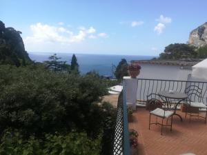 a balcony with a table and chairs and the ocean at Hotel Della Piccola Marina in Capri