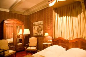 een slaapkamer met een bed, een stoel en een dressoir bij Stadspaleis Hotel & Restaurant OldRuitenborgh in Vollenhove