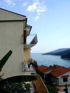 ein Gebäude mit Balkon und Blick auf das Wasser in der Unterkunft Apartments Villa Adria in Rabac