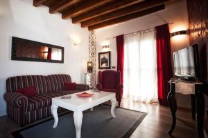 uma sala de estar com um sofá e uma mesa em Singular Siete Revueltas em Sevilha