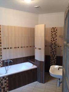 a bathroom with a bath tub and a sink at Liget in Balatonföldvár