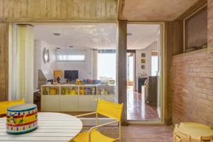 a living room with a table and yellow chairs at Terrazza Marina in Porto Santo Stefano