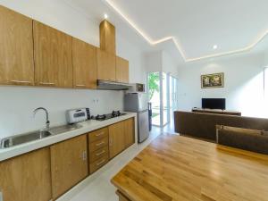 a kitchen with wooden cabinets and a stainless steel refrigerator at Anna villa 4 in Sanur
