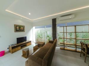 a living room with a couch and a television at Anna villa 4 in Sanur