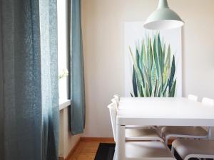 une salle à manger avec une table blanche et une plante sur le mur dans l'établissement 2ndhomes Mikonkatu Apartment, à Helsinki