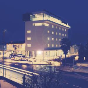 a large building with cars parked in a parking lot at Le Nove Hotel in Nove