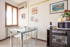 a kitchen with a table and chairs and a microwave at Residenza "Il Torrazzo" in Cremona